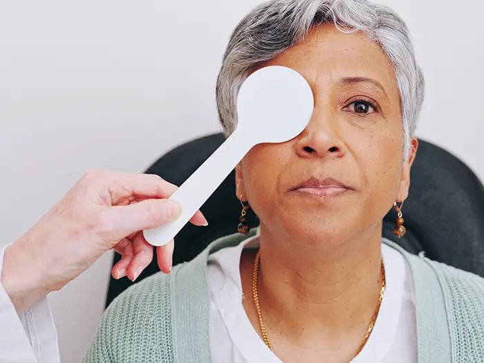 Senior woman having one eye covered during vision test